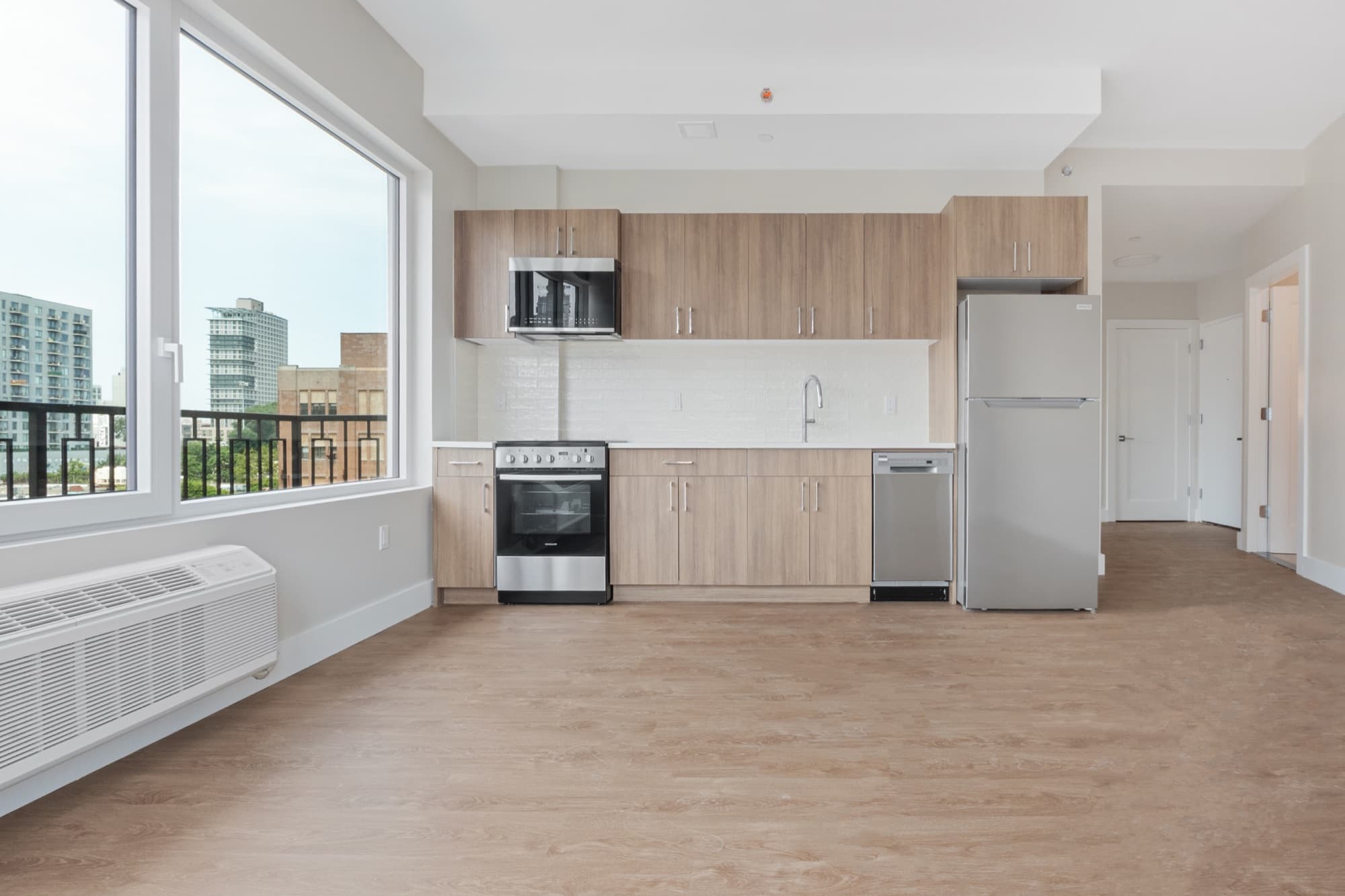 Una residencia iluminada en The Astelle con ventanales amplios sobre Mott Haven, que evoca la vida del edificio más allá del hogar